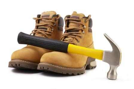 working boots and hammer isolated on white background selective focus